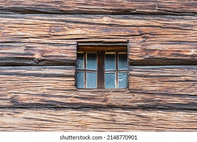 Closeup Of A Square Little Window Carved In An Old, Wooden Surface Or Facade. Detail Of Cute Tiny Window On A Timber - Made Or Timbered Exterior Of A Viking House. Mini Casement On An Chalet Building