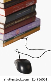 Close-up of a stack of books and a computer mouse