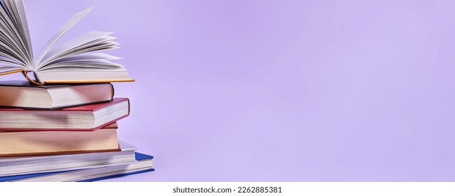 Close-up of a stack of books with one open book on top - Powered by Shutterstock