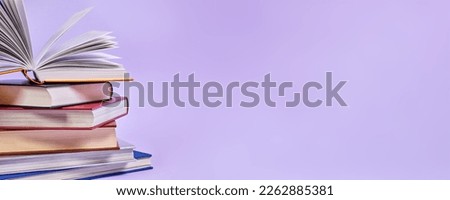 Close-up of a stack of books with one open book on top