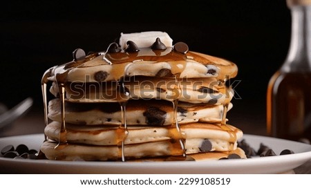 A close-up of a stack of chocolate chip pancakes, drizzled with maple syrup.