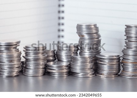 A close-up of a stack of coins on a note background.