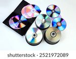 Closeup of a stack compact disc CD and DVD. High resolution compact disc texture CD or DVD. Disks CD, DVD for background. CD, DVD disc unsorted on the ground with light effect. isolated background