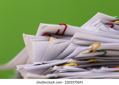 Close-up Of Stack Of Group Report Papers Document Clipped On Green Background, Business, And Education Concept.