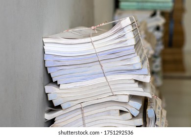 Close-up of the stack of many old white books that are tied together by ropes placed inside the room.