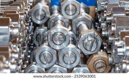 Closeup of a stack of nuts and bolts with engraved abbreviations for material, tensile strength and technical standard.