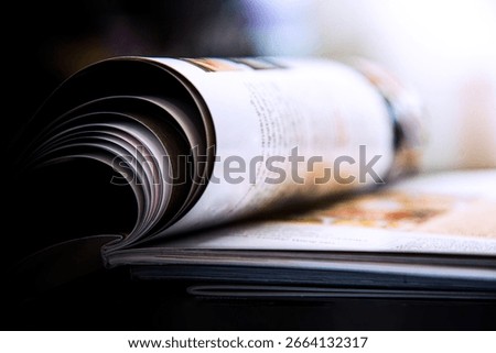 Close-up of a stack of open books on a desk in an office. Selective focus