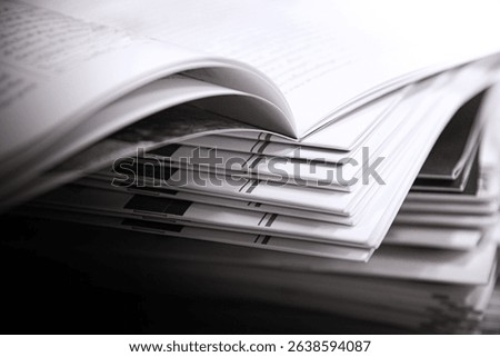 Close-up of a stack of open magazines on a table in a university library. Shallow depth of field.