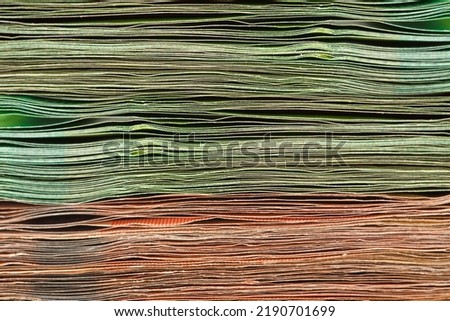 Close-up of a stack of paper bills, side view. Euro banknotes stacked on top of each other. Big pile of money.