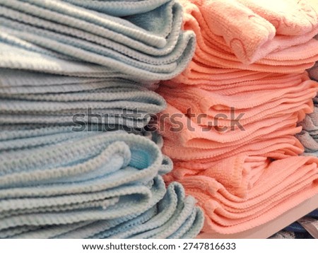 closeup of a stack of pink and blue towels neatly arranged on a display rack