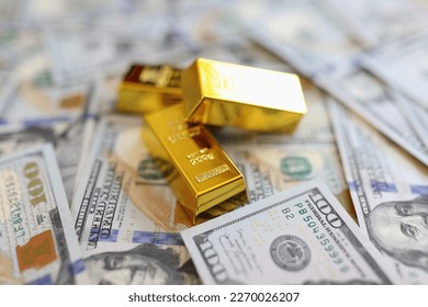 Close-up of stack small golden ingots on pots of money cash. Accumulation of wealth and self-insurance concept