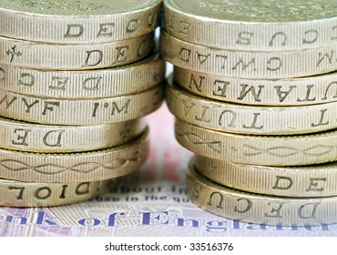 Close-up Of Stack Of UK Pound Coins On Bank Note