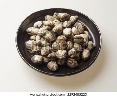 Close-up of stacked raw cockles on black jar, South Korea
