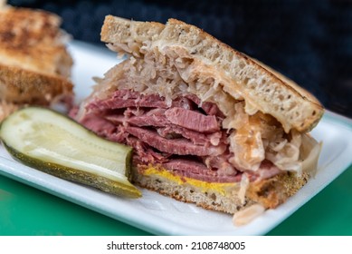 Closeup Of Stacked Reuben Sandwhich With Pickle, Sauerkraut And Mustard From A Deli.