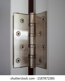 close-up stainless steel door hinge on wooden swing door for interior design. copy space.