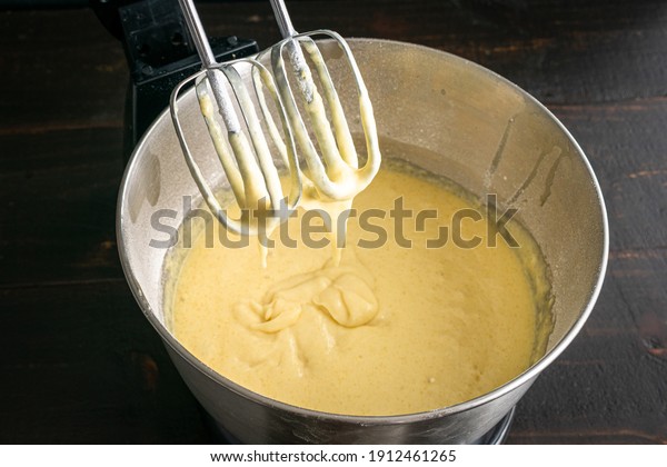 Closeup of Stand Mixer Beaters in Above Vanilla Cake\
Batter: Cake batter that has been mixed in an electric stand mixer\
bowl