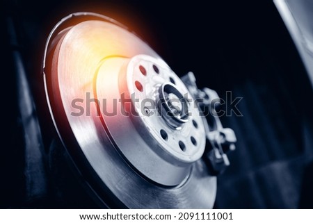 Closeup steel brake disk and detail of wheel hub with sunlight. Concept replacing wheel pads in garage car service.
