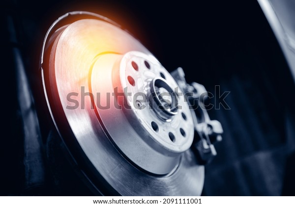 Closeup steel\
brake disk and detail of wheel hub with sunlight. Concept replacing\
wheel pads in garage car\
service.
