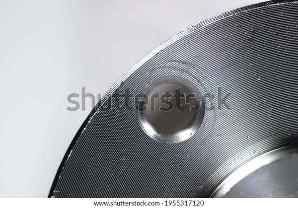 A\
close-up of a steel car hub flange. Very shallow depth of field\
with focus on only a small portion of the\
flange