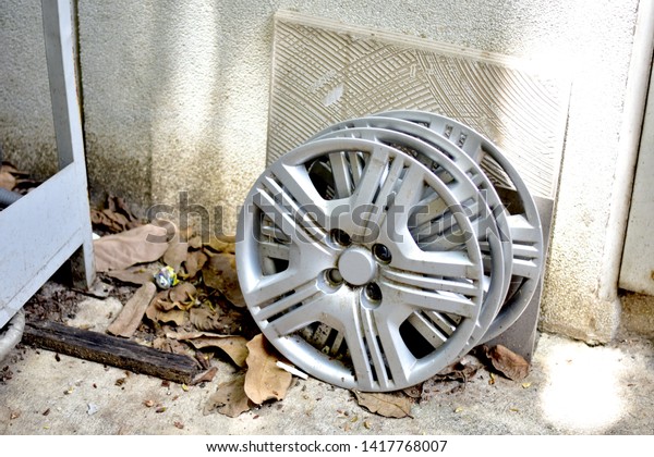 Closeup of Steel Car wheel cover placed beside the\
wall, Selective focus.