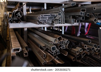 Closeup Of Steel Shaped Tubes And Profiles On Shelving Rack In Metalworking Workshop..