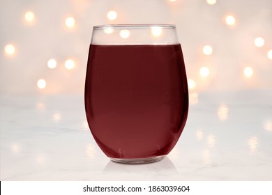 Closeup Of A Stemless Wineglass Filled With Red Wine. Shining White Lights Give This No Stem Wine Glass Mockup A Touch Of Elegance.