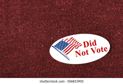 Closeup of a sticker with an American flag and the words "Did Not Vote" placed on a red shirt.