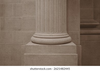  A close-up of a stone column base featuring fluted shaft design and a robust square plinth, reflecting classical architectural style. The neutral-toned stone surface is textured and evenly lit.