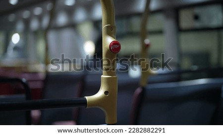 Closeup Stop button inside British bus interior of public transportation at night