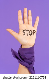 Closeup of stop message on protestor's hand. Feminism, gender violence and equality concept