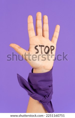 Closeup of stop message on protestor's hand. Feminism, gender violence and equality concept