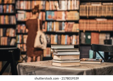 Close-up of stops of books, book store, library. Silhouette of abstract girl. Education, school, study, reading concept. Blurred background