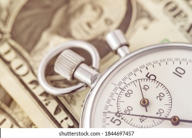 Close-up of a stopwatch on the background of the dollar banknote. Dollar close-up. Money macro shot. Time is money concept - Shutterstock ID 1844697457