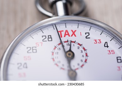 Closeup of stopwatch showing Tax Time concept - Shutterstock ID 230430685