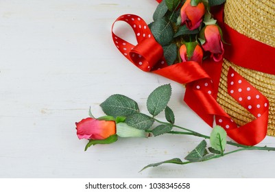 Closeup Of A Straw Hat Being Decorated With Red Ribbons And Roses On A White Washed Rustic Wooden Background. Good For Kentucky Derby. Copy Space