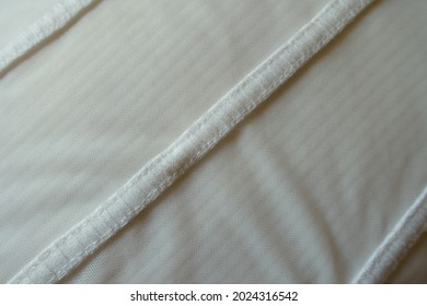 Closeup Of Stripes Of White Fabric Seamed To Mesh