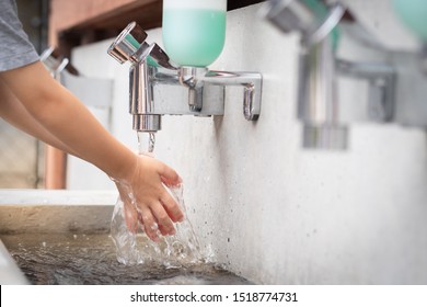 Closeup: A Student Boy Washing Hands At The Outdoor Wash Basin In The School. Preventing Contagious Diseases. Plague. Kids Health, Hygiene, Flu, H5N1 Influenza, Saving Water, Cleaning, Running Water.