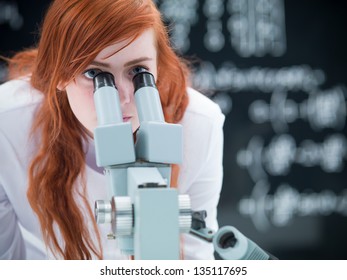 Close-up Of A Student In A Chemistry Lab Looking In The Camera While Analyzing Under Microscope