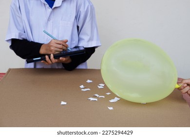 Closeup student doing science experiment about static electricity lesson from balloon. Observe ,takes note. Concept, Action research. Science project work. Learning by doing and observing. Education. 