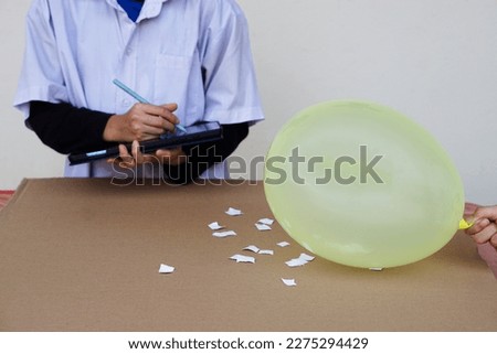 Closeup student doing science experiment about static electricity lesson from balloon. Observe ,takes note. Concept, Action research. Science project work. Learning by doing and observing. Education. 