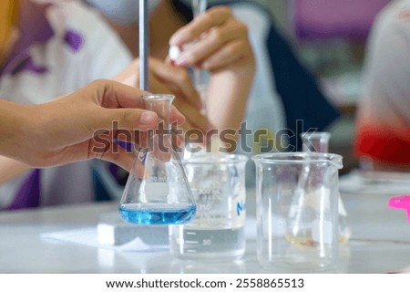 Close-up of a student performing an acid-base titration experiment. Concept of chemistry lab, science, experiment, skills, learning.                           