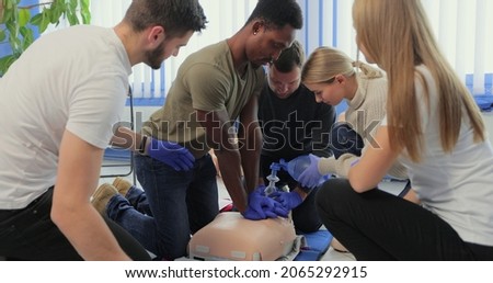 Closeup of students practicing CPR chest compression on dummy.