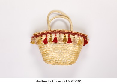 Closeup studio isolated shot of fashionable Asian modern classic style handmade handicraft woven weaving rattan grass lady female woman shopping handbag purse with colorful tassel on white background.