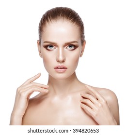 Closeup studio portrait of young beautiful model with professional makeup on white background. Perfect fresh clean skin. Deep blue eyes. Brunette hair. Hands near face. Isolated