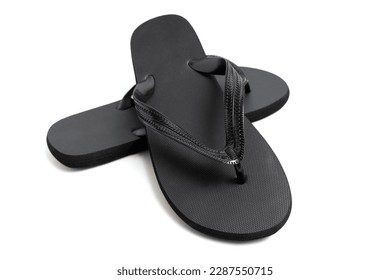 A close-up studio shot of a pair of black flip-flops isolated against a white background.