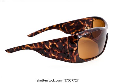 A Closeup Studio Shot Of A Pair Of Brown Tortoise Pattern Plastic Sunglasses.