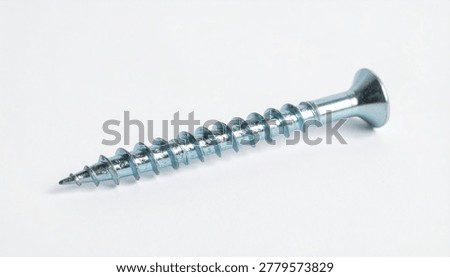 A close-up studio shot of a single silver-colored metal wood screw, positioned diagonally and isolated on a clean white background.