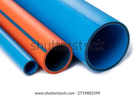 Close-up studio shot of three large, durable plastic pipes in varying shades of blue and vibrant orange, isolated on a white background.