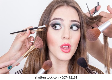 Closeup Of Stunned Beautiful Blond Girl Getting Hair And Makeup Done Isolated Over White