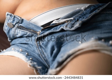 A close-up of a stylish denim short with a white belt, highlighting the trendy fashion details and the casual, laid-back vibe of summer attire